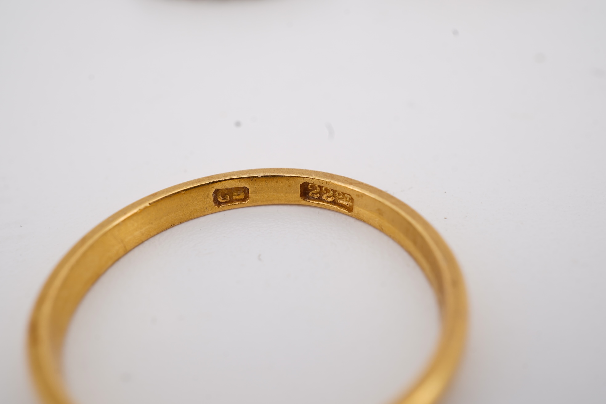 A 22ct wedding band, size M, 2 grams, an 18ct, plat and single stone diamond ring, a a modern 9ct gold, sapphire and diamond cluster ring and a yellow metal and white stone, eternity ring.